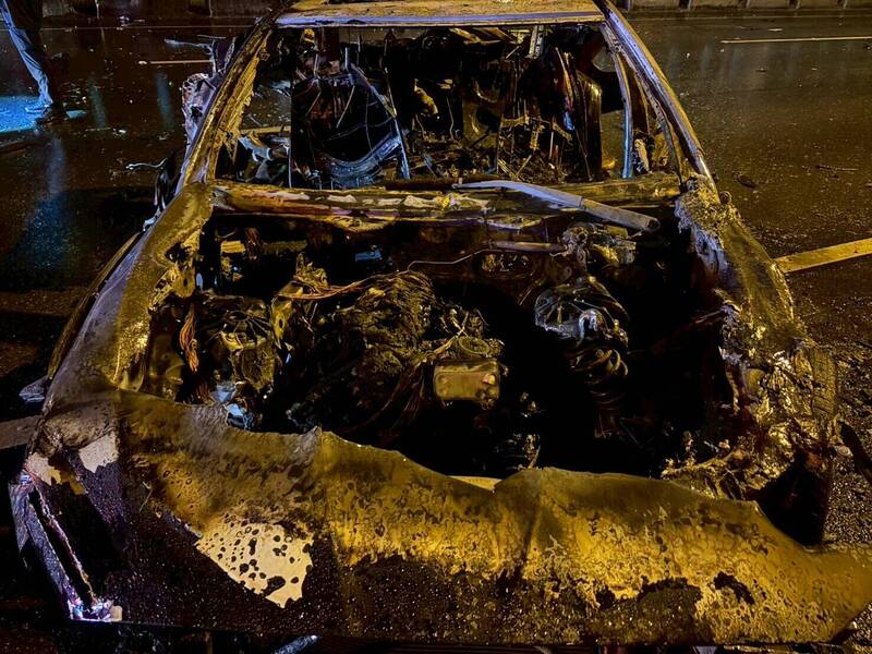 轎車不明原因自撞護欄、橋墩後起火燃燒，整部車子燒到面目全非。（高市消防局提供）