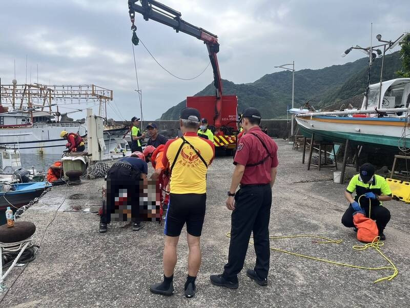 消防隊員將死者遺體吊掛上岸。（記者吳昇儒翻攝）
