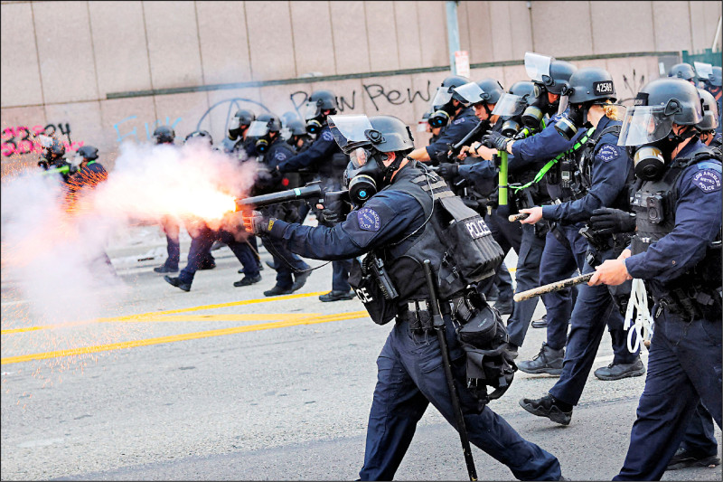 美國移民暨海關執法局（ICE）6日在洛杉磯逮捕非法移民，引發民眾集結抗議，警方向示威者發射閃光彈。（路透）