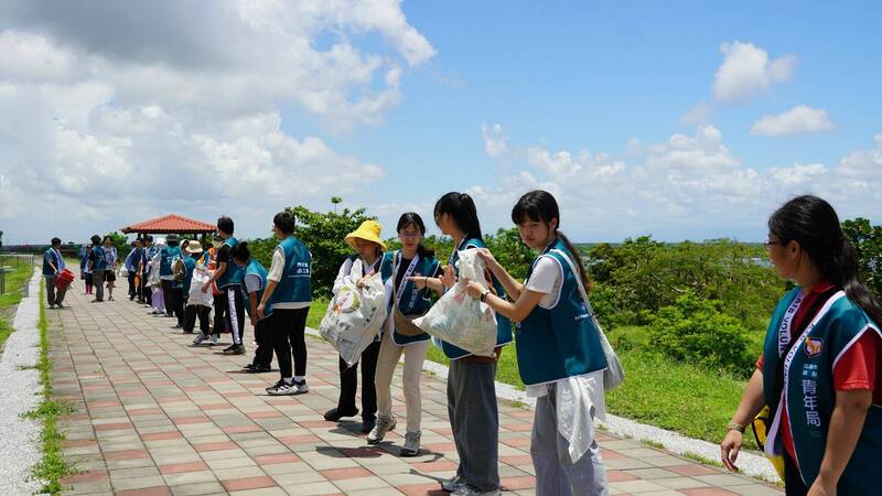 淨灘志工在短短兩小時內,即清理38袋垃圾,並透過人龍接力移至清運點。(青年局提供) 淨灘志工在短短兩小時內,即清理38袋垃圾,並透過人龍接力移至清運點。(青年局提供)