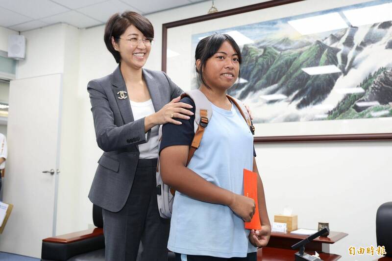 南投縣長許淑華協助榮獲今年總統教育獎的田萱背上縣府贈送的文青背包,並表示將自掏腰包幫她買一把好弓。(記者張協昇攝) 南投縣長許淑華協助榮獲今年總統教育獎的田萱背上縣府贈送的文青背包,並表示將自掏腰包幫她買一把好弓。(記者張協昇攝)