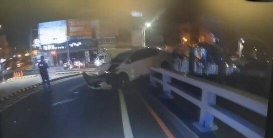 張女開男友偷來的車撞分隔島,轎車滑行到進德大橋護欄停下,險些墜入東港溪。(警方提供) 張女開男友偷來的車撞分隔島,轎車滑行到進德大橋護欄停下,險些墜入東港溪。(警方提供)
