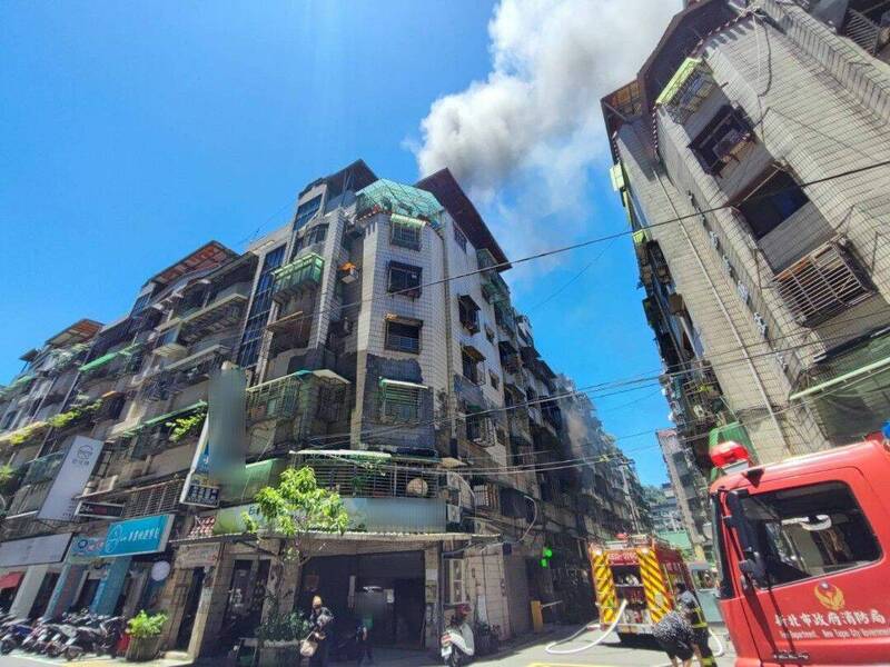 新北市新店區安民街一棟公寓發生火警,警消趕抵時,發現2樓竄出大量濃煙,消防人員隨即佈水線灌救。(記者陸運鋒翻攝) 新北市新店區安民街一棟公寓發生火警,警消趕抵時,發現2樓竄出大量濃煙,消防人員隨即佈水線灌救。(記者陸運鋒翻攝)