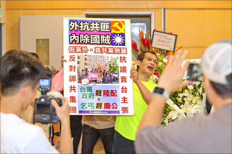「黨外在野大聯盟」成立大會昨在台大校友會館舉行，過程中有民眾到場抗議，持標語看板高喊「舔共大聯盟」，隨即被架離現場。（中央社）