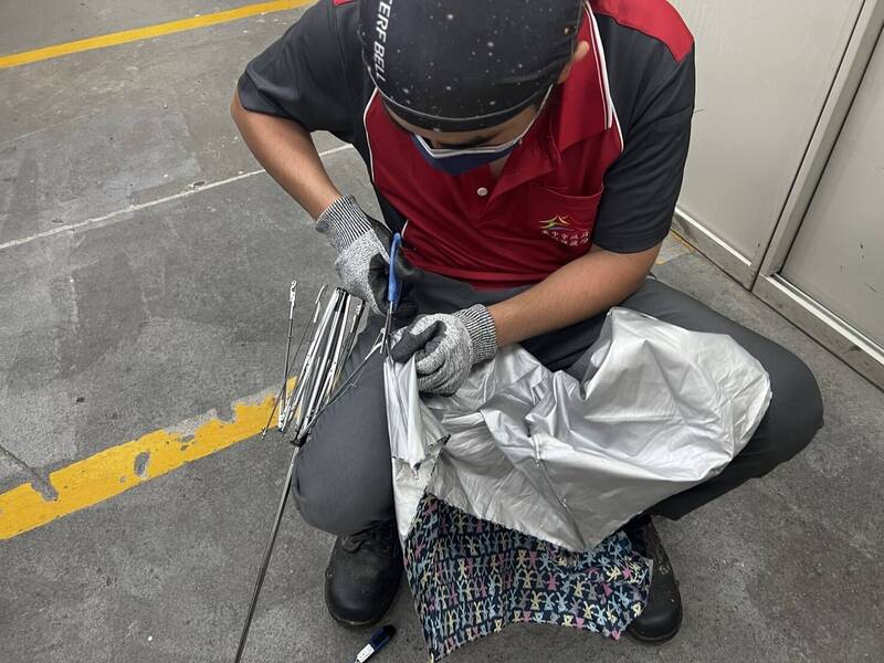 清潔隊員拆除雨傘骨架、傘面,製成購物袋及飲料杯帶。(台中市環保局提供) 清潔隊員拆除雨傘骨架、傘面,製成購物袋及飲料杯帶。(台中市環保局提供)