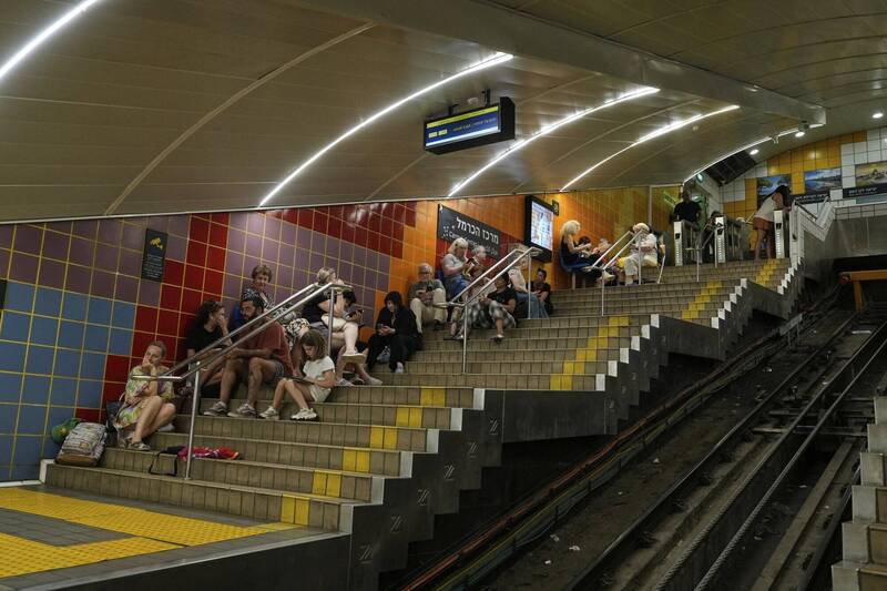 以色列空襲警報響起，人們躲進地下地鐵站。（美聯社）