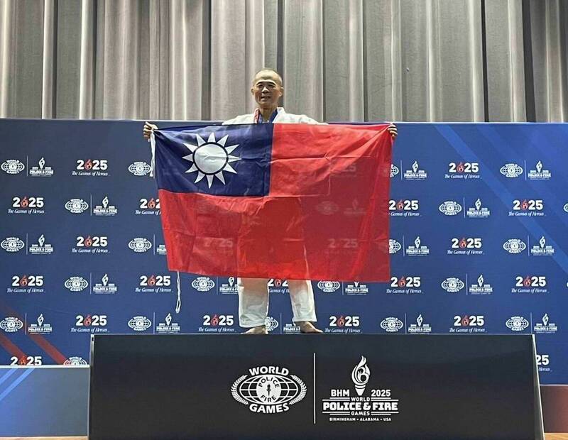 彰化縣警局訓練科長林世明在世界警消運動會柔道賽奪金,現場大秀國旗。(林世明提供) 彰化縣警局訓練科長林世明在世界警消運動會柔道賽奪金,現場大秀國旗。(林世明提供)