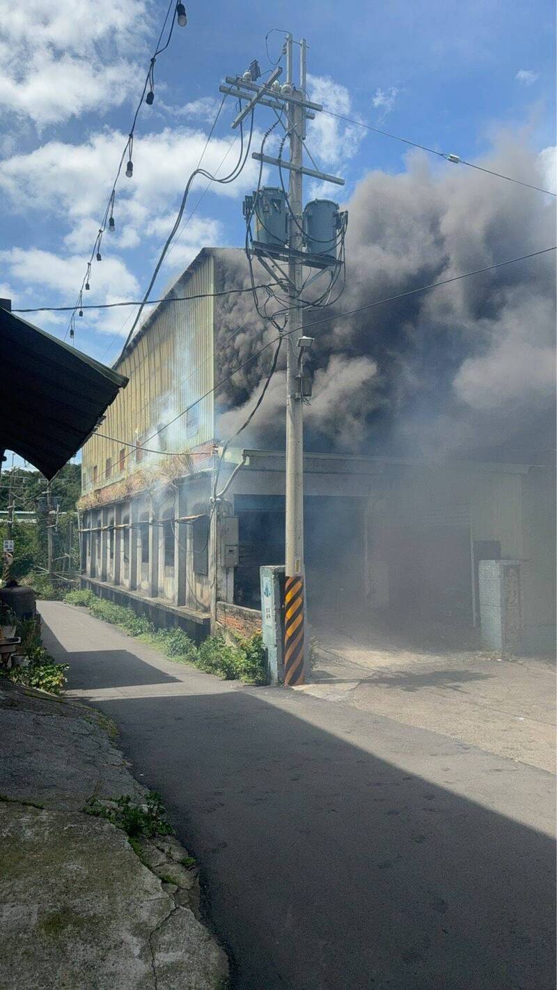 新北市八里区一间铁皮木材加工厂发生火警,冒出浓密黑烟。(记者徐圣伦翻摄) 新北市八里区一间铁皮木材加工厂发生火警,冒出浓密黑烟。(记者徐圣伦翻摄)