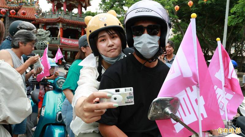 潘小姐帶著即可拍相機,紀錄難得一見的罷免機車隊遊行。(記者黃政嘉攝) 潘小姐帶著即可拍相機,紀錄難得一見的罷免機車隊遊行。(記者黃政嘉攝)