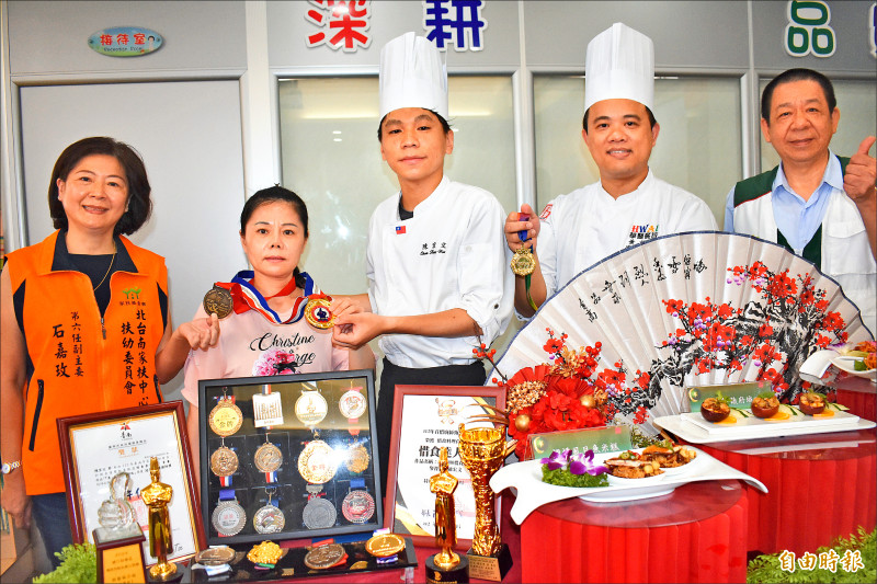 北台南家扶生陳宏文(中)接連在新加坡、韓國首爾國際廚藝競賽勇奪五面金牌,昨天在感恩餐會,將金牌獻給媽媽祁金霞(左二)。(記者楊金城攝) 北台南家扶生陳宏文(中)接連在新加坡、韓國首爾國際廚藝競賽勇奪五面金牌,昨天在感恩餐會,將金牌獻給媽媽祁金霞(左二)。(記者楊金城攝)