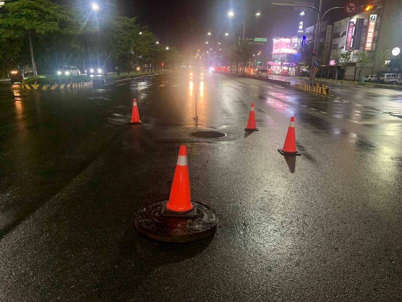路面人孔蓋竟被水壓「頂飛」暴走。(警方提供) 路面人孔蓋竟被水壓「頂飛」暴走。(警方提供)