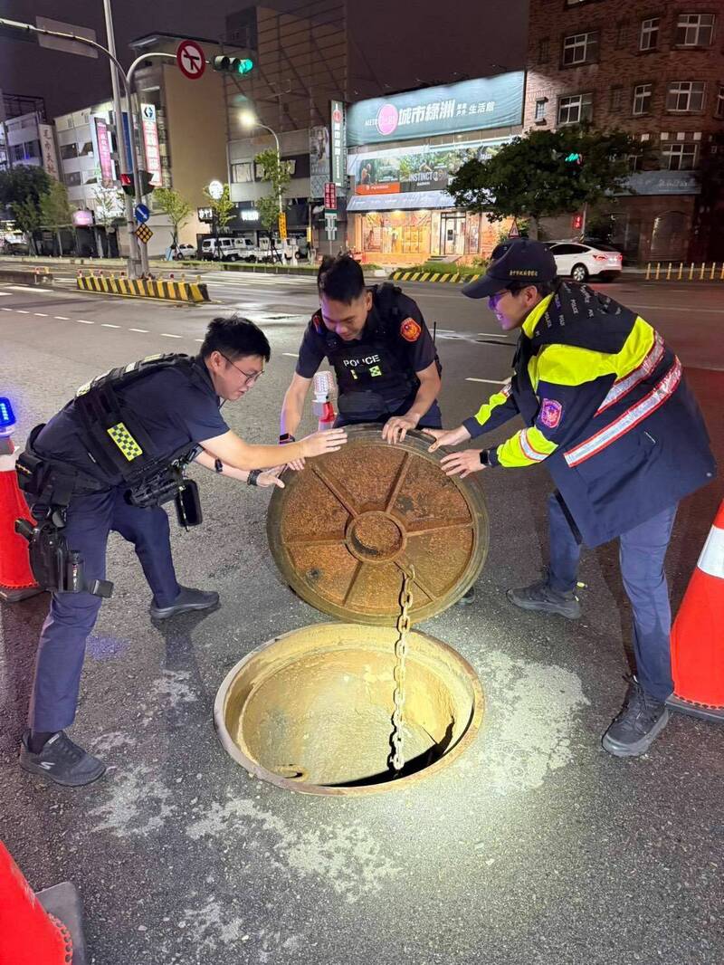 3名警力合力上陣,終於將「脫軌」人孔蓋搬回原處。(警方提供) 3名警力合力上陣,終於將「脫軌」人孔蓋搬回原處。(警方提供)