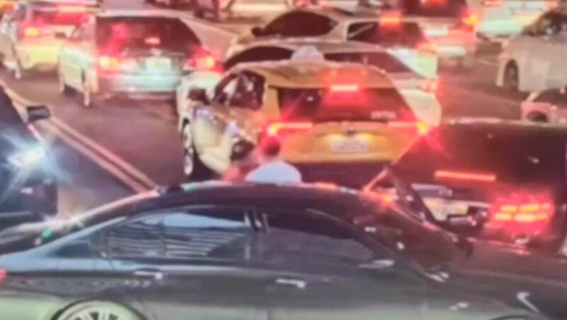 朱男駕車左轉時因前方車多壅塞,鄭姓義交指示應保持淨空,要求朱男後退時,雙方認知問題爆發肢體衝突。(記者陸運鋒翻攝) 朱男駕車左轉時因前方車多壅塞,鄭姓義交指示應保持淨空,要求朱男後退時,雙方認知問題爆發肢體衝突。(記者陸運鋒翻攝)