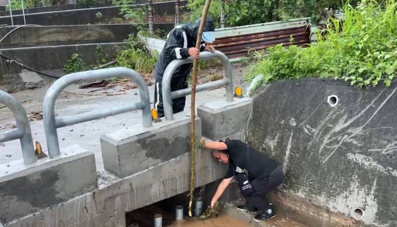 村落民眾伸手撈取卡住溝渠的雜草。(民眾提供) 村落民眾伸手撈取卡住溝渠的雜草。(民眾提供)