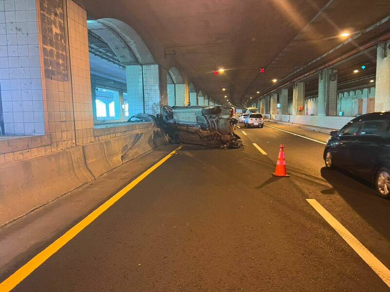 新竹縣鳳鼻隧道今天上午1輛聯結車與自小客車碰撞,自小客車整個翻覆在北上的車道上。(新竹縣消防局提供) 新竹縣鳳鼻隧道今天上午1輛聯結車與自小客車碰撞,自小客車整個翻覆在北上的車道上。(新竹縣消防局提供)