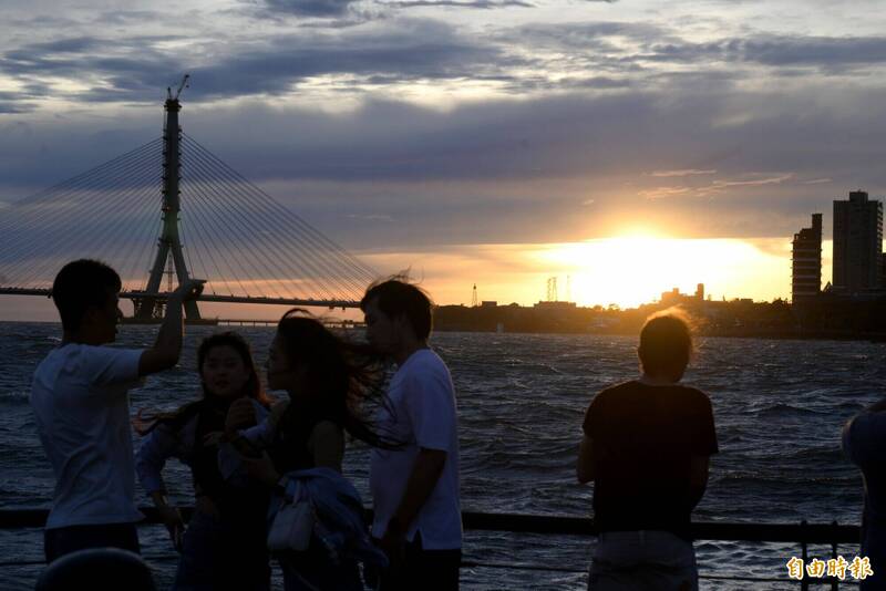 淡水河岸6日傍晚湧現大批民眾頂著強風,前往漁人碼頭及河岸邊觀賞夕陽。(記者王藝菘攝) 淡水河岸6日傍晚湧現大批民眾頂著強風,前往漁人碼頭及河岸邊觀賞夕陽。(記者王藝菘攝)
