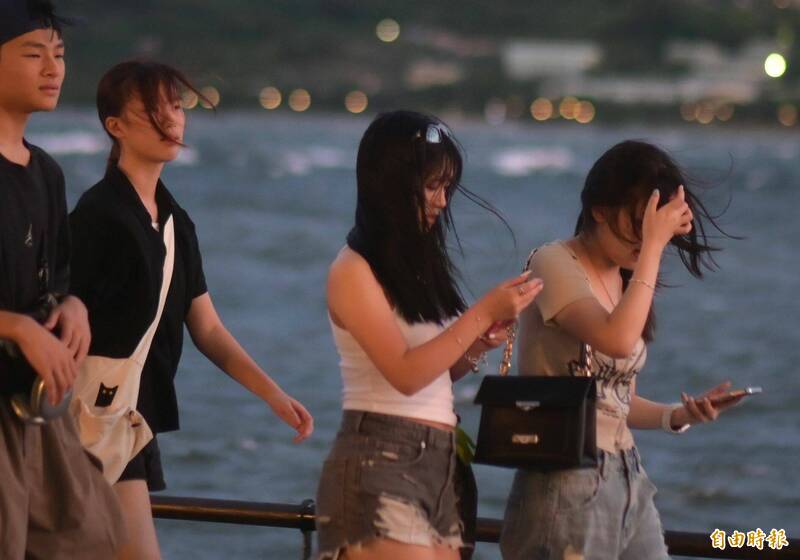 淡水河岸6日傍晚湧現大批民眾頂著強風,前往漁人碼頭及河岸邊觀賞夕陽。(記者王藝菘攝) 淡水河岸6日傍晚湧現大批民眾頂著強風,前往漁人碼頭及河岸邊觀賞夕陽。(記者王藝菘攝)
