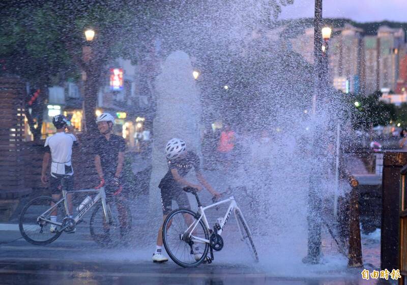 淡水河岸有騎單車經過的民眾直接衝進浪花中,與從岸邊噴湧而出的河水「近距離接觸」,全身濕透仍笑得開懷。(記者王藝菘攝) 淡水河岸有騎單車經過的民眾直接衝進浪花中,與從岸邊噴湧而出的河水「近距離接觸」,全身濕透仍笑得開懷。(記者王藝菘攝)