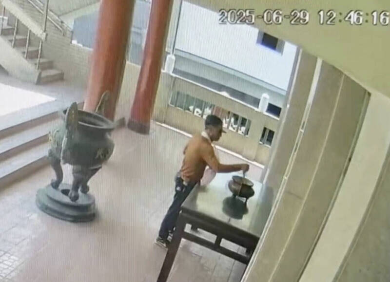 監視器拍到,胡男拿出剪刀,然後對著供桌前的香爐狂插。(民眾提供) 監視器拍到,胡男拿出剪刀,然後對著供桌前的香爐狂插。(民眾提供)