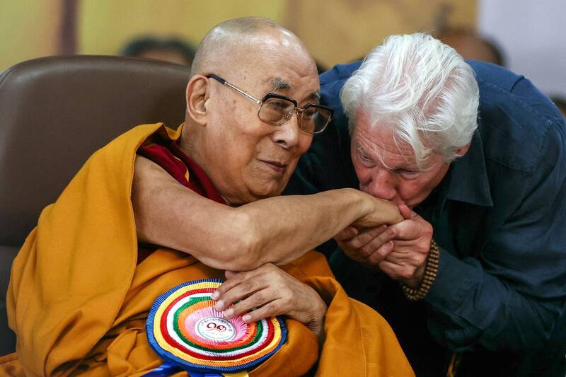 西藏精神領袖達賴喇嘛於7月6日迎來90歲大壽,長期支持他的好萊塢影星李察基爾(右)也親赴印度達蘭薩拉的慶典,並親吻其手背致意。(法新社) 西藏精神領袖達賴喇嘛於7月6日迎來90歲大壽,長期支持他的好萊塢影星李察基爾(右)也親赴印度達蘭薩拉的慶典,並親吻其手背致意。(法新社)