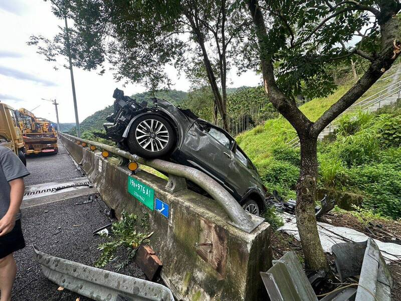 灰色休旅车追撞前方轿车后冲出护栏，最后倒挂在护栏上。（民众提供）