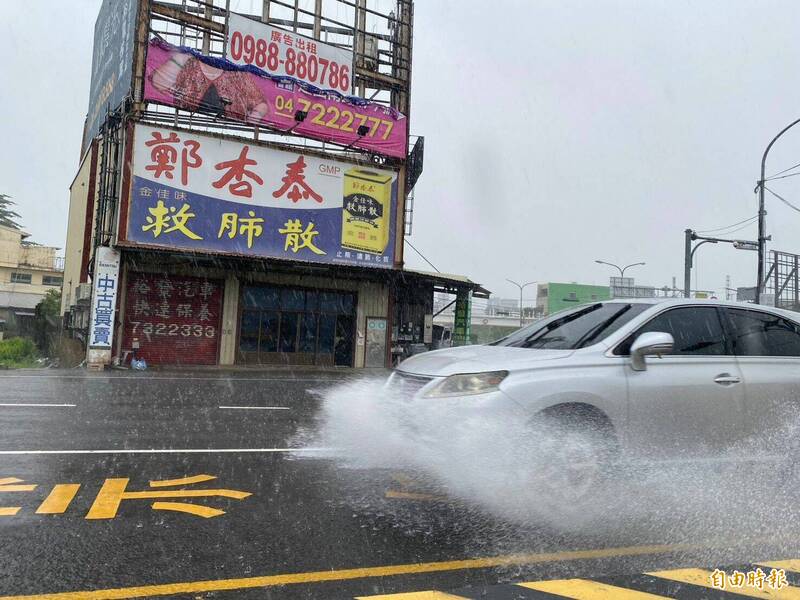 雷雨突襲造成彰化市金馬東街、中山路一帶路面積水,汽車疾駛捲起大片水花。(記者張聰秋攝) 雷雨突襲造成彰化市金馬東街、中山路一帶路面積水,汽車疾駛捲起大片水花。(記者張聰秋攝)