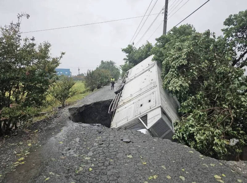 彰化暴雨不断，二林二溪路7段路面突然塌陷，一辆行经的货车当场陷入坑洞。（民众提供）