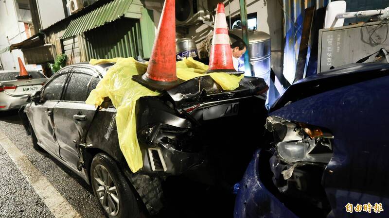 前面遭撞擊的黑色轎車車尾嚴重變形。(記者黃政嘉攝) 前面遭撞擊的黑色轎車車尾嚴重變形。(記者黃政嘉攝)