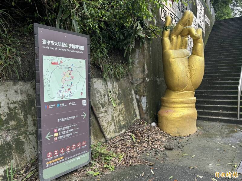 大坑第14條步道登山口有一隻巨大的金色佛手。（記者許國楨攝）