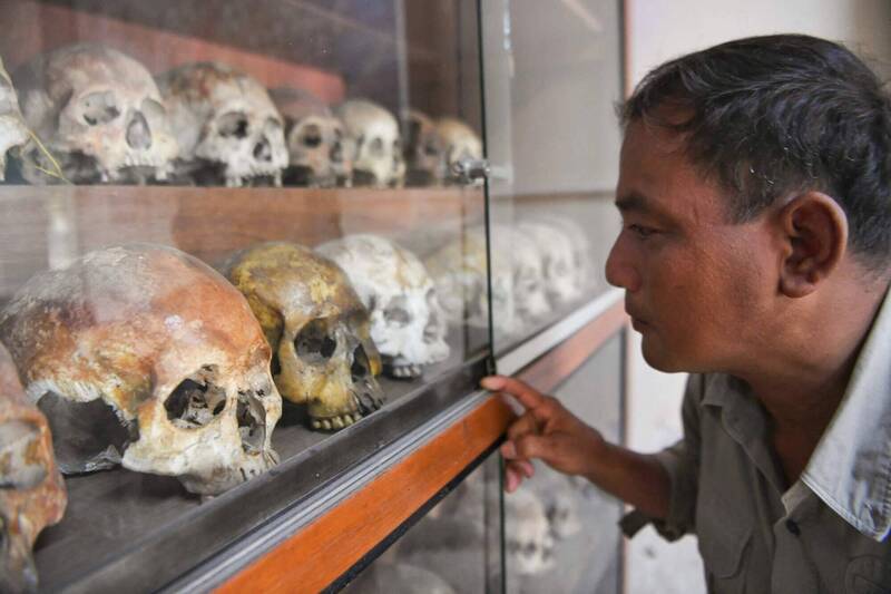 一名赤柬屠殺倖存者在金邊杜斯廉屠殺博物館內，凝視展示櫃中的受害者頭骨。此處原為S-21監獄，這次與另兩處屠殺遺址一同被列入聯合國教科文組織世界遺產名錄。（法新社）