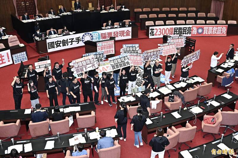 立法院院會11日三讀通過「因應國際情勢強化經濟社會及民生國安韌性特別條例」,民進黨團舉牌反對普發現金。(資料照) 立法院院會11日三讀通過「因應國際情勢強化經濟社會及民生國安韌性特別條例」,民進黨團舉牌反對普發現金。(資料照)