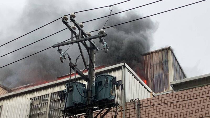 桃園市平鎮區平東路一段178巷1間塑膠射出工廠，今晨2樓不明原因起火燃燒，竄起濃煙。（記者黃政嘉翻攝）