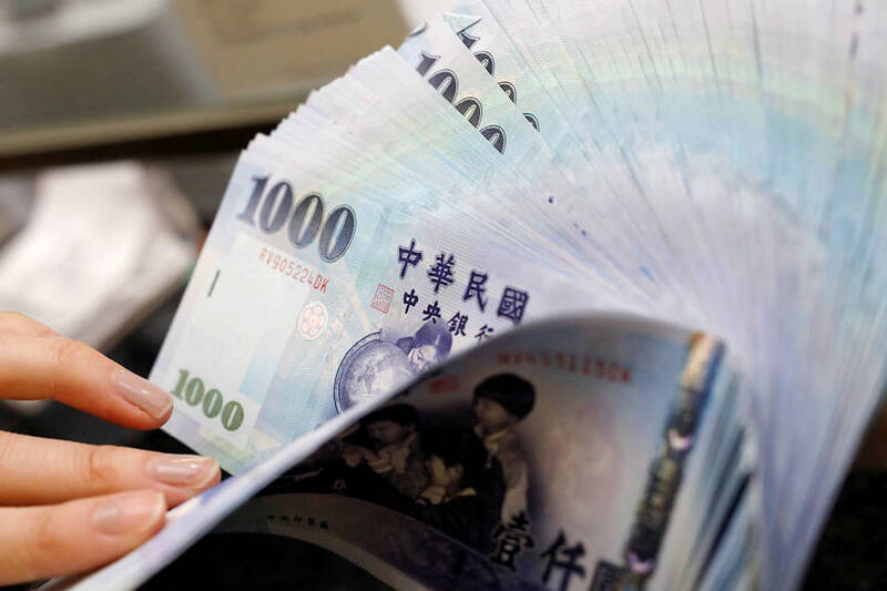 A teller counts NT$1,000 banknotes at a bank in Taipei on Feb. 23, 2017.
Photo: Tyrone Siu, Reuters A teller counts NT$1,000 banknotes at a bank in Taipei on Feb. 23, 2017.
Photo: Tyrone Siu, Reuters