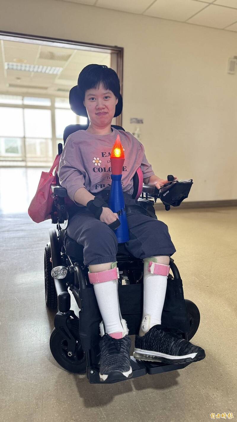 八里愛心教養院運動會聖火進場,由重度腦性麻痺院生小貞擔任火炬手。(記者翁聿煌攝) 八里愛心教養院運動會聖火進場,由重度腦性麻痺院生小貞擔任火炬手。(記者翁聿煌攝)