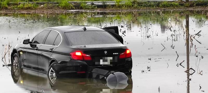 拒絕國道警察攔檢的黑色BMW轎車掉落安定交流道旁的水塘,警方抵達時,駕駛已逃逸。(記者劉婉君翻攝) 拒絕國道警察攔檢的黑色BMW轎車掉落安定交流道旁的水塘,警方抵達時,駕駛已逃逸。(記者劉婉君翻攝)