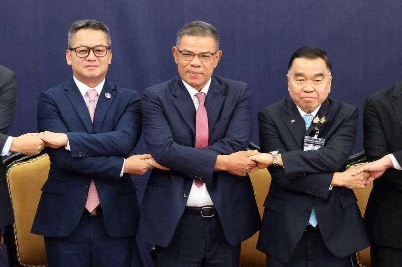 泰國副國防部長納塔蓬（左）、柬埔寨國防部長塞哈（右）與馬來西亞內政部長賽義夫丁（中）握手合影。（法新社）