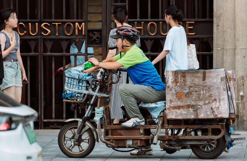 中國自9月起嚴厲執行社保繳費，引發廣大網友舉台灣年金改革實例呼籲檢討高福利。圖為上海街頭的外送員。（歐新社檔案照）