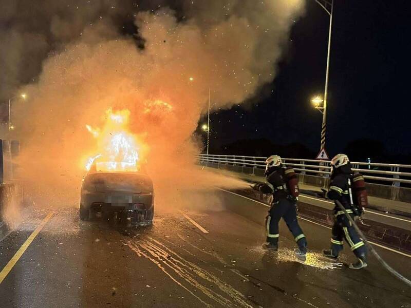 整輛轎車被大火吞噬濃煙竄天，消防員灌救。（圖由消防局提供）