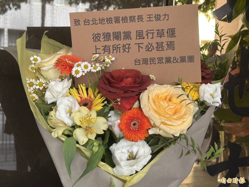 周榆修手捧「彼獠閹黨，風行草偃；上有所好，下必甚焉」的鮮花，指今天這幾束花是用來「打醒北檢」。（記者劉詠韻攝）