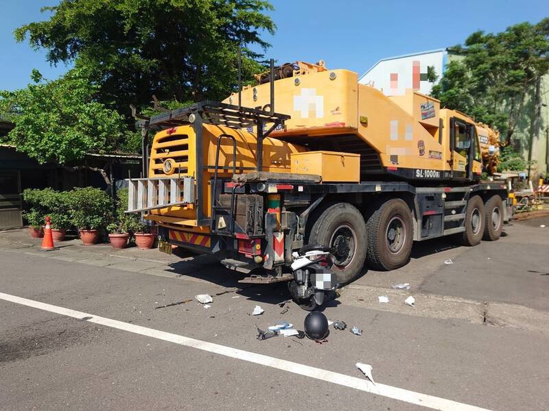 機車捲入吊車車底，血跡斑斑。（民眾提供）