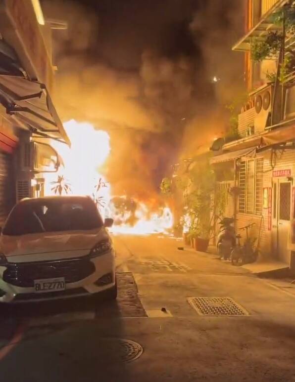 新北市新店區行政街今天凌晨3時，一輛停在巷內汽車突然起火燃燒，還不時傳出爆炸聲響，大批警消趕抵時，火勢猛烈且延燒至隔壁民宅。（Threads網友seans_0710授權）