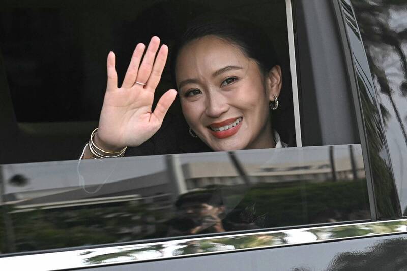 泰國總理貝東塔被泰國憲法法院裁定解職，她在離開總理府時揮手致意。（法新社）