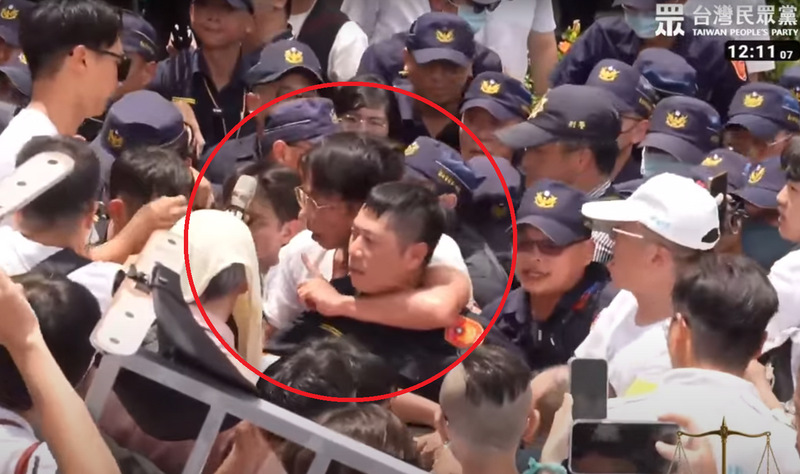 黃國昌用手臂持續勒住警察數十秒。（圖擷自民眾黨YT直播）