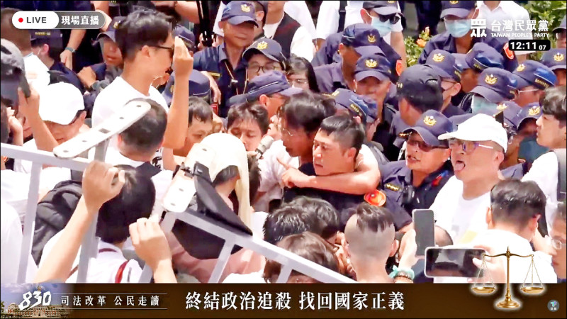 民眾黨昨舉辦「司法改革公民走讀」活動，黨主席黃國昌率「小草」多次欲衝撞警方圍欄拒馬，黃失控一度勒住負責安全維護警官的脖子。（取自民眾之聲YouTube）