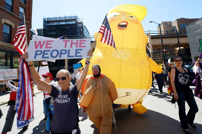 美國9月1日勞動節當天，全國爆發「工人對決億萬富翁」大示威，劍指川普政府的親富豪政策。圖為芝加哥的示威現場，民眾高舉標語，並帶著諷刺川普總統的巨大氣球走上街頭。（法新社）