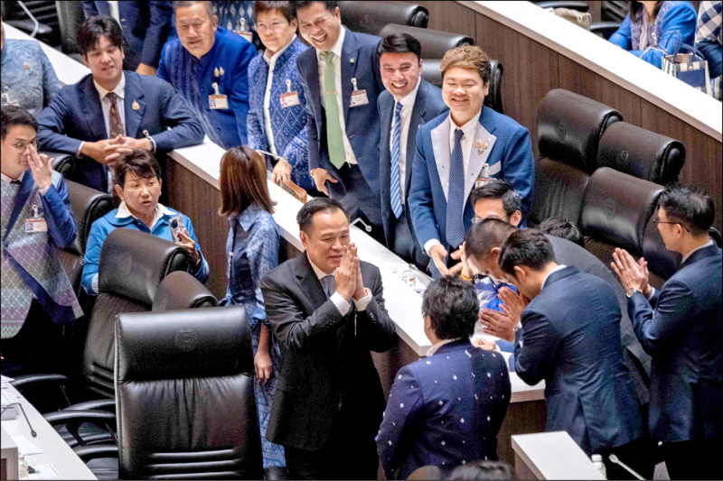 泰自豪黨黨魁阿努廷（圖中）五日經國會表決當選總理後，笑容滿面地向道賀的議員行合十禮致意。（法新社）