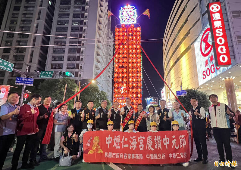 桃園市長張善政（中）等人出席中壢慶讚中元活動，讚嘆傳統人力拉抬豎立約3層樓高的大型水燈排震撼無比。（記者李容萍攝）