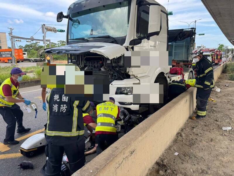 桃園市蘆竹區南青路發生嚴重車禍，一對老夫婦騎乘機車被砂石車撞擊捲入車底，救護人員獲報趕往現場施救。（記者余瑞仁翻攝）
