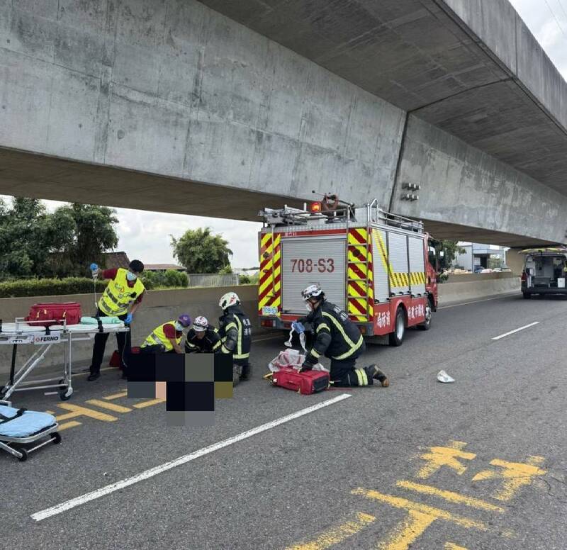 桃園市蘆竹區南青路發生嚴重車禍，一對老夫婦騎乘機車被砂石車撞擊捲入車底，救護人員獲報趕往現場施救。（記者余瑞仁翻攝）