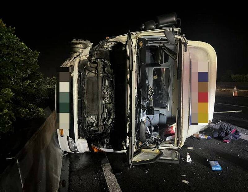 半聯結車撞擊國道護欄後翻覆，車頭嚴重毀損。（圖由國道警方提供）